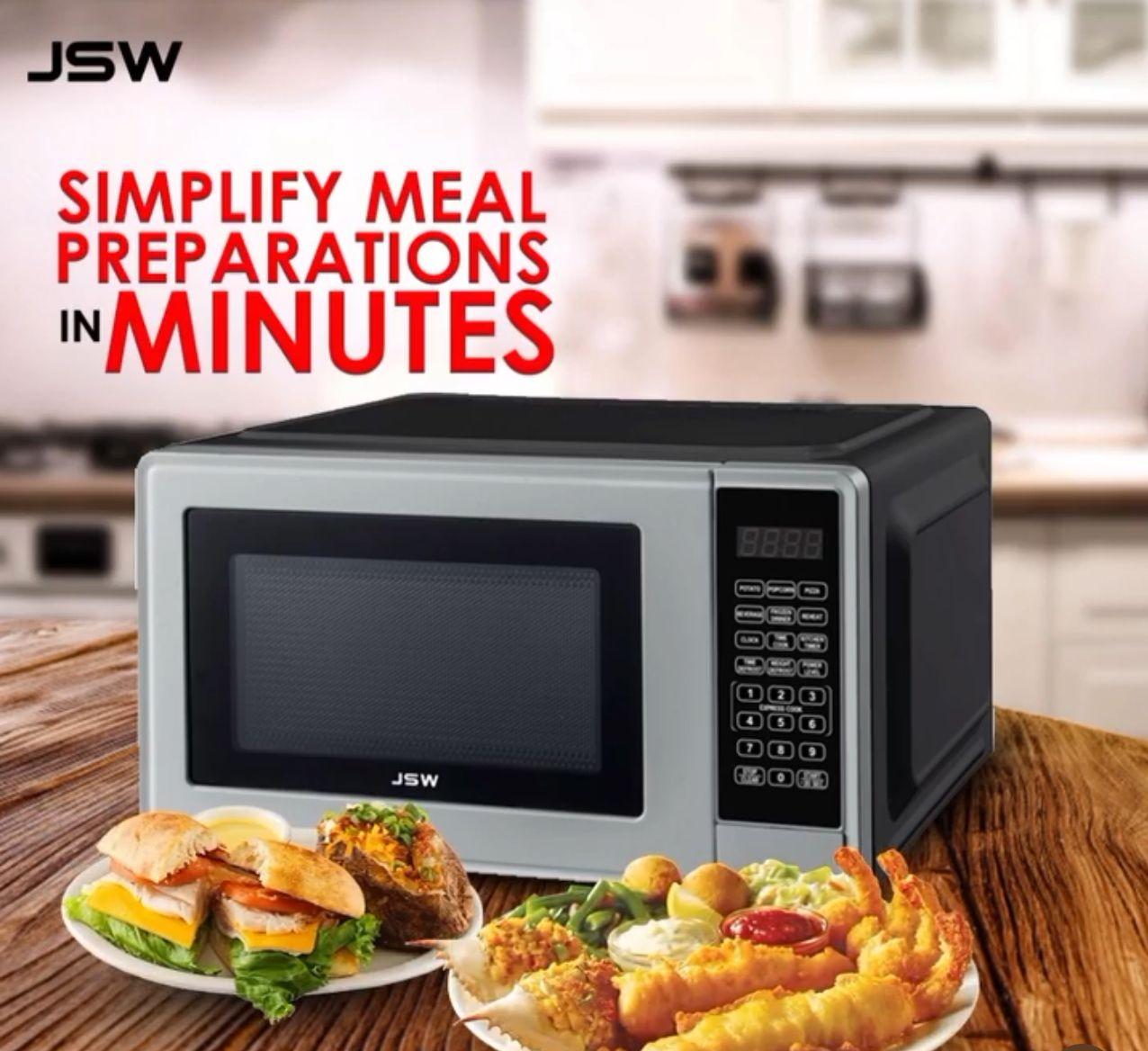 JSW microwave on a wooden table with plates of food, promoting simplified meal preparations in minutes.